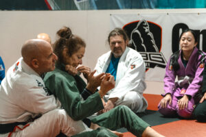 Coach demonstrating a Jiu Jitsu technique to adult beginners at SBG Calgary