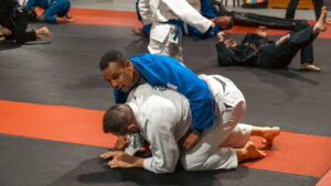 Two adults training Jiu Jitsu under coach supervision in Calgary