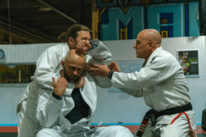 Beginner adult learning Brazilian Jiu Jitsu at Straight Blast Gym Calgary, practicing safely on the mats to build fitness and confidence.