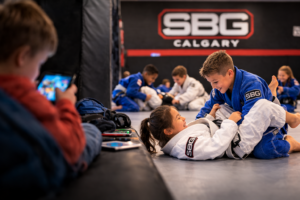 Children practicing Brazilian Jiu-Jitsu during a class at Straight Blast Gym Calgary as a healthy alternative to too much screen time
